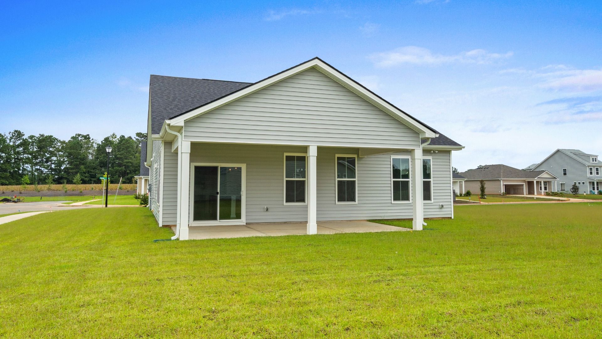 Rear view of Easton Elevation 5 at Chestnut Farms in Longs, SC, showcasing a covered back porch and spacious yard