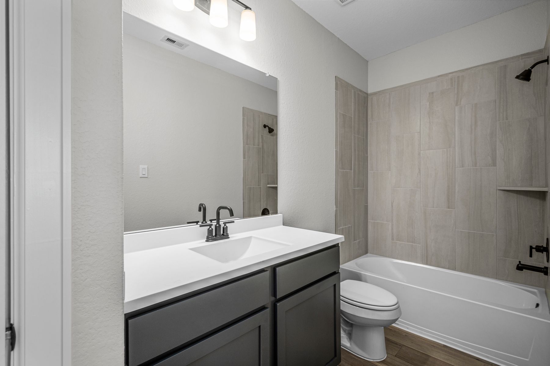 This secondary bathroom has a tub/shower combination. 