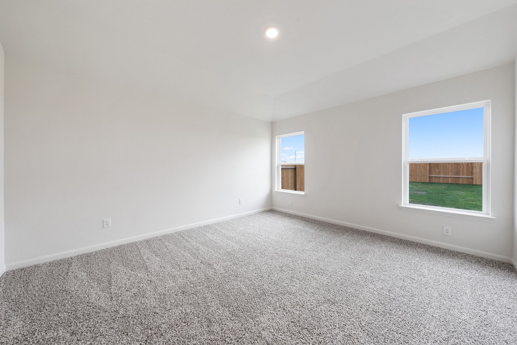 The large master bedroom has windows with great natural light and backyard views.
