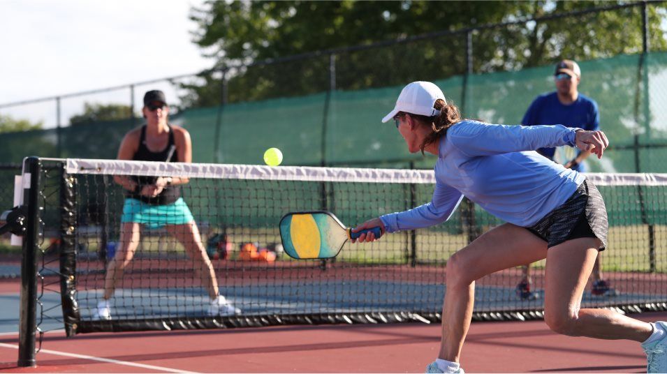 Adults playing a game of pickleball