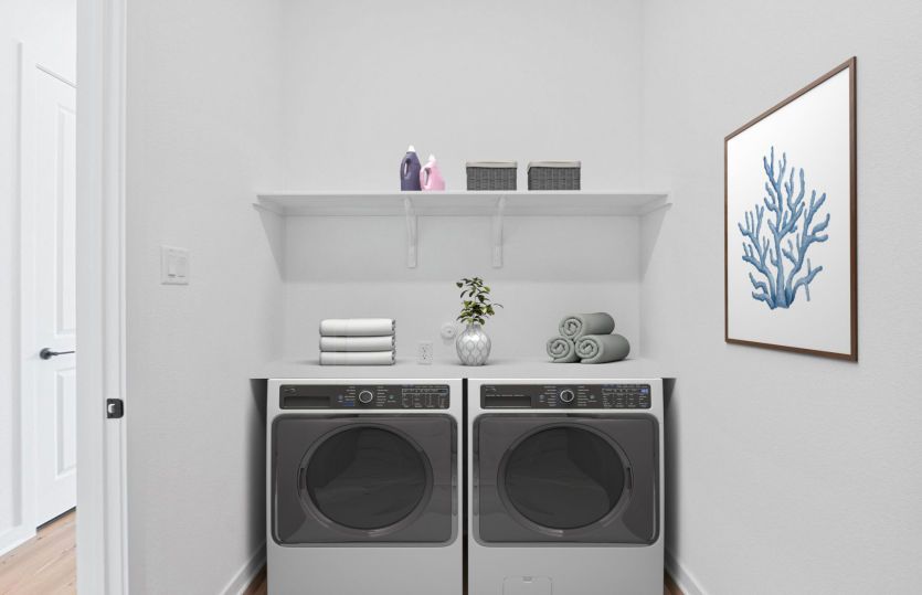 Dedicated laundry room with convenient storage and functional workspace.