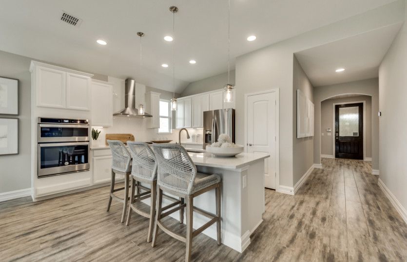 Welcoming entry into island kitchen with eat-in bartop
