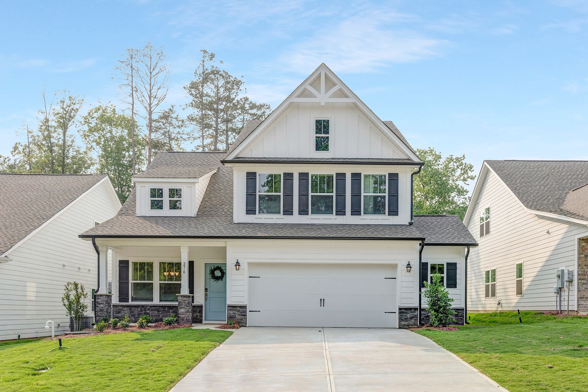 A large white house with a gray roof and black shutters