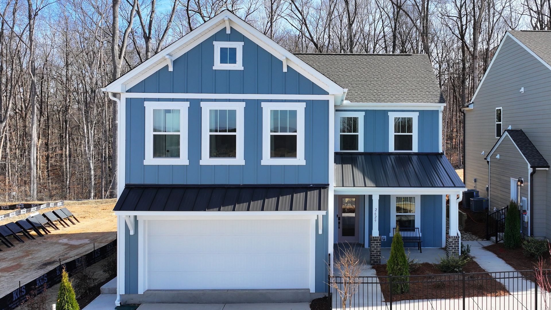 A blue and white house with a garage and a porch.